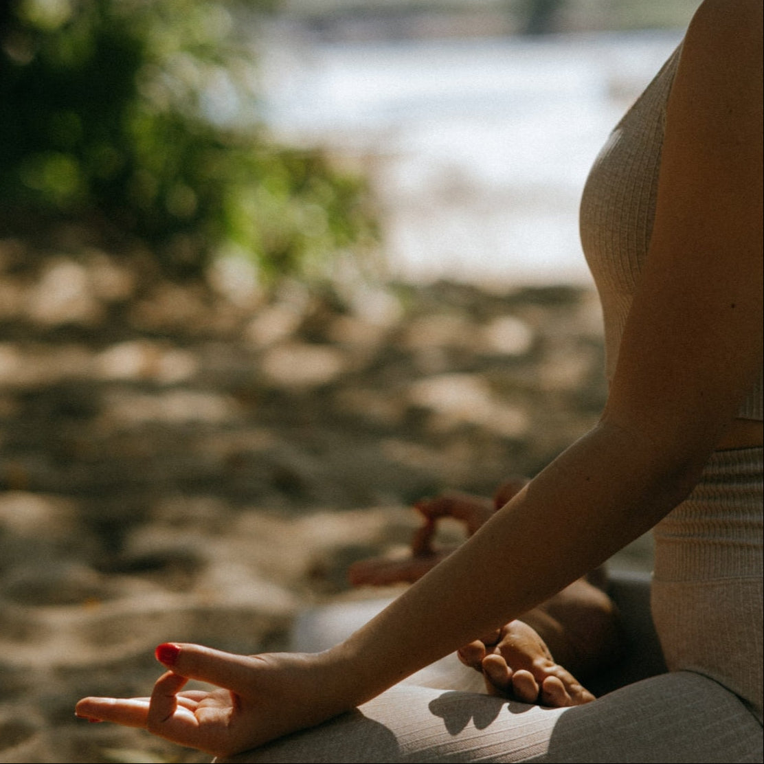 Trifora Wellness' mental health supplements collection image on the home page. Woman meditating in nature.
