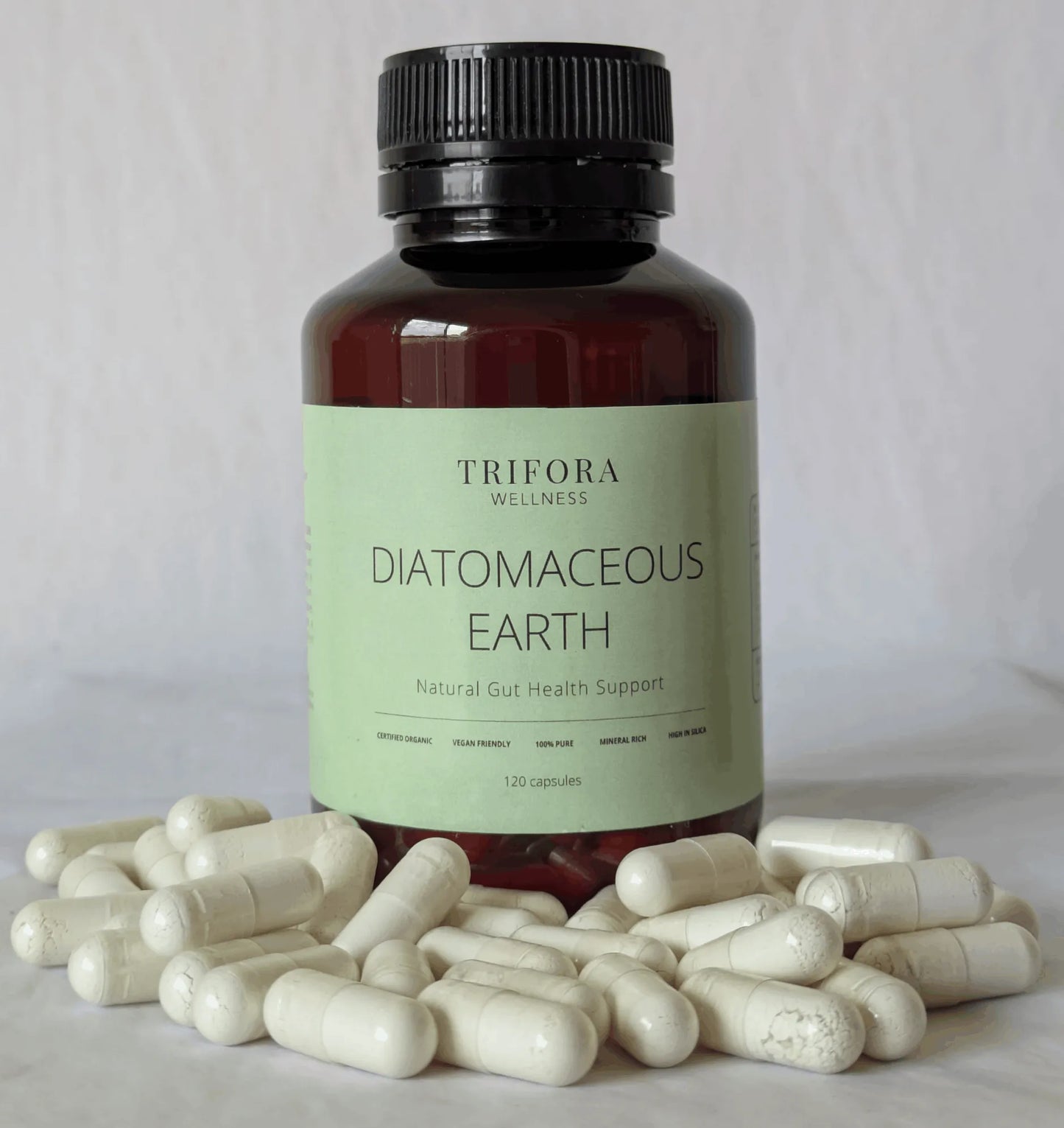 Bottle of Trifora Wellness Diatomaceous Earth supplement with capsules on a light background